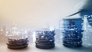 Double exposure of city and rows of coins for finance and banking concept