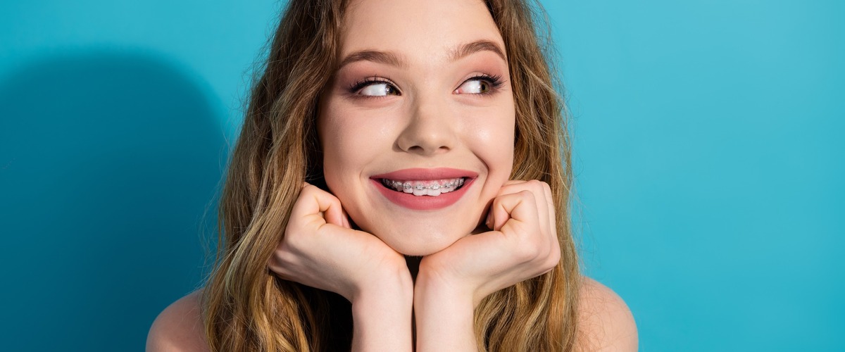 Junge Frau lächelt und zeigt ihre Zahnspange