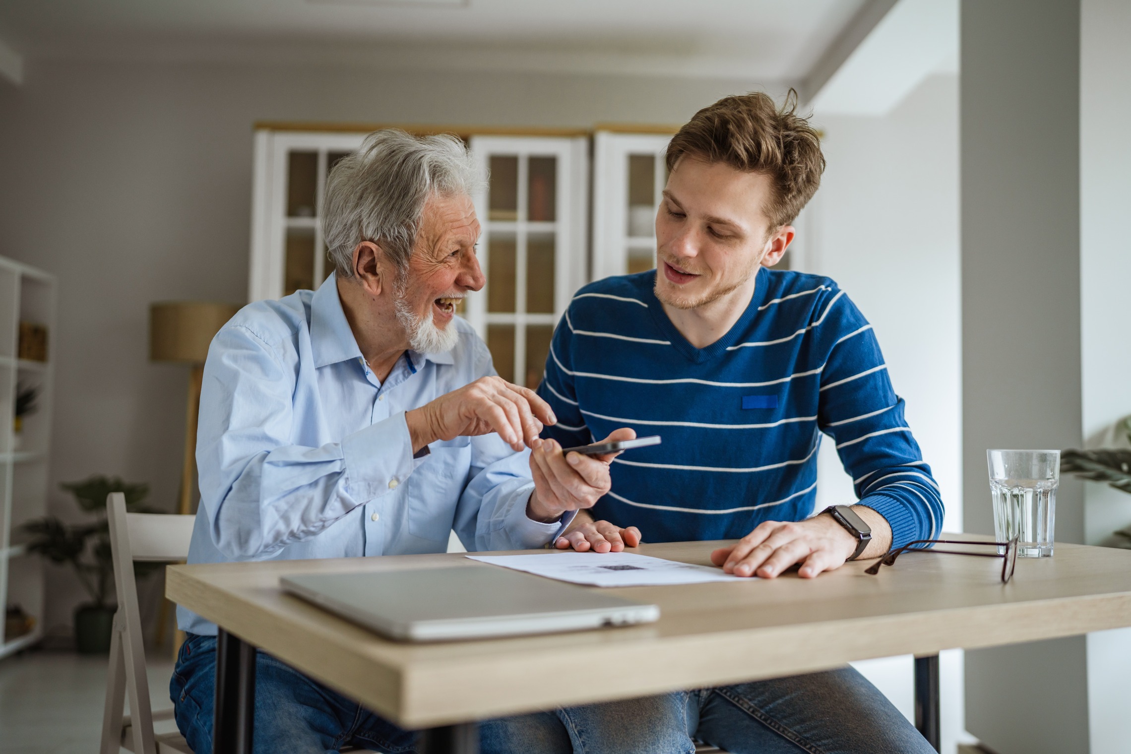 Einen Notfallplan Das Bild zeigt einen älteren Mann, der mit einem jungen Mann an einem Tisch sitzt.